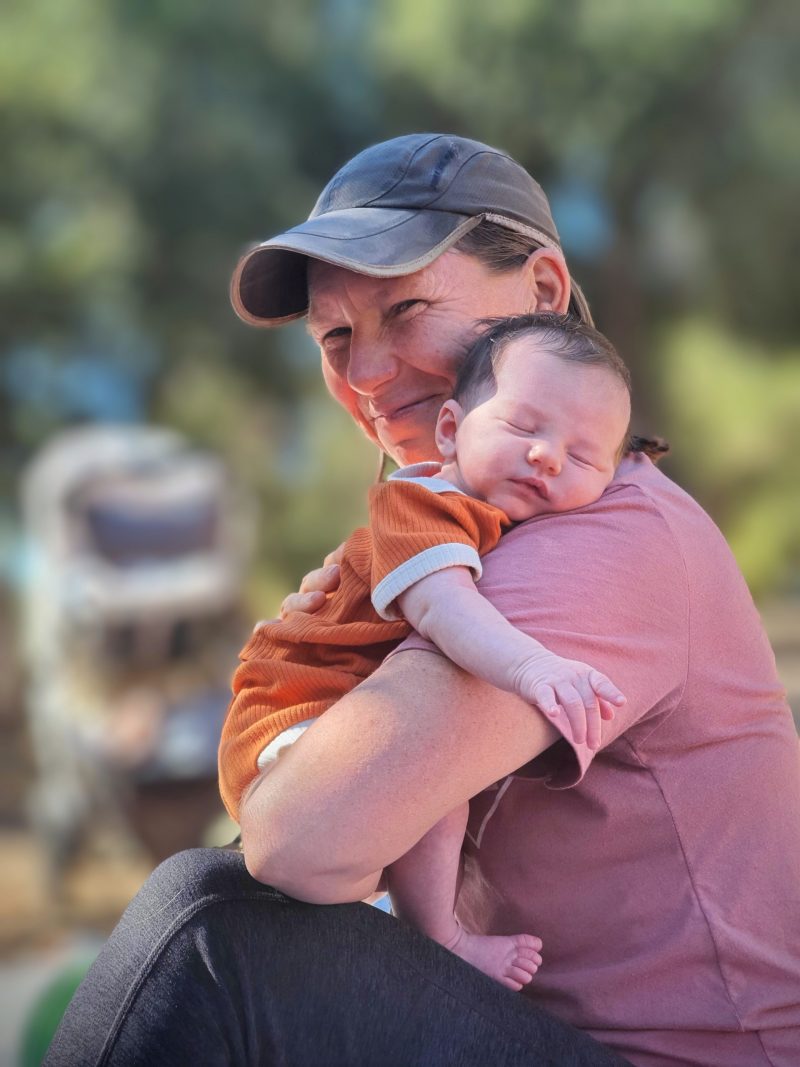 Tania holding a sleeping newborn at Libbey Park in Ojai, CA