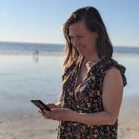 Tania working on her phone at the beach in Ventura.